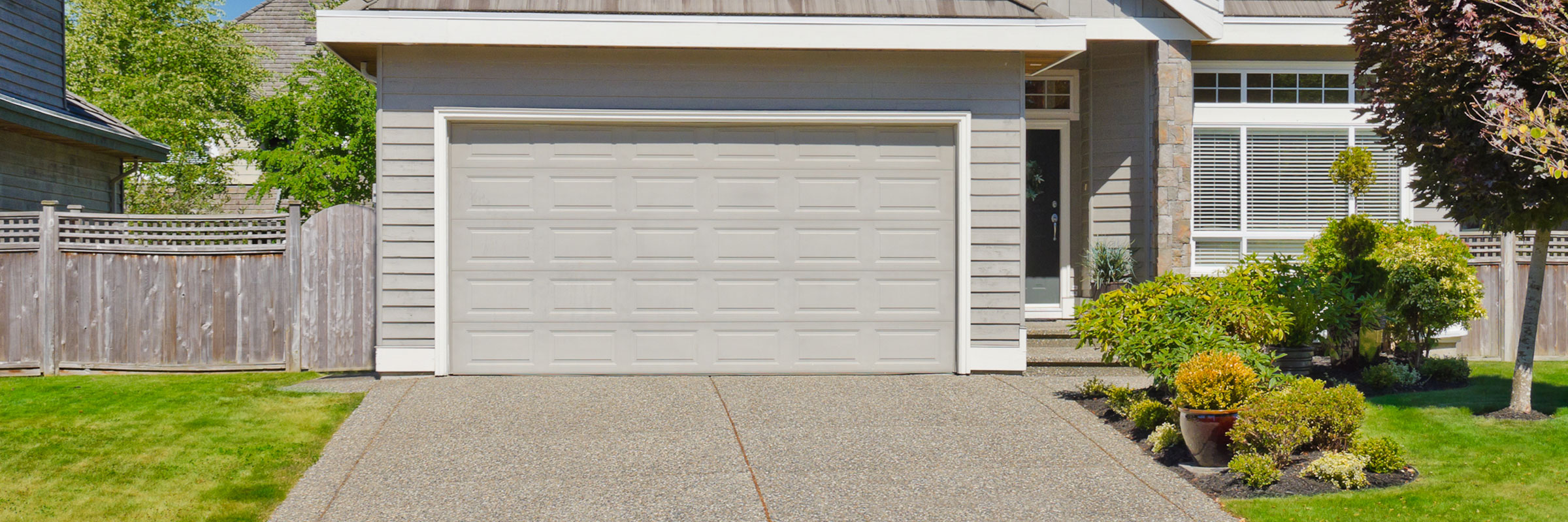 garage door in spring conditions with beautiful greenery behind the house the garage door is on garage door in spring conditions with beautiful greenery behind the house the garage door is on