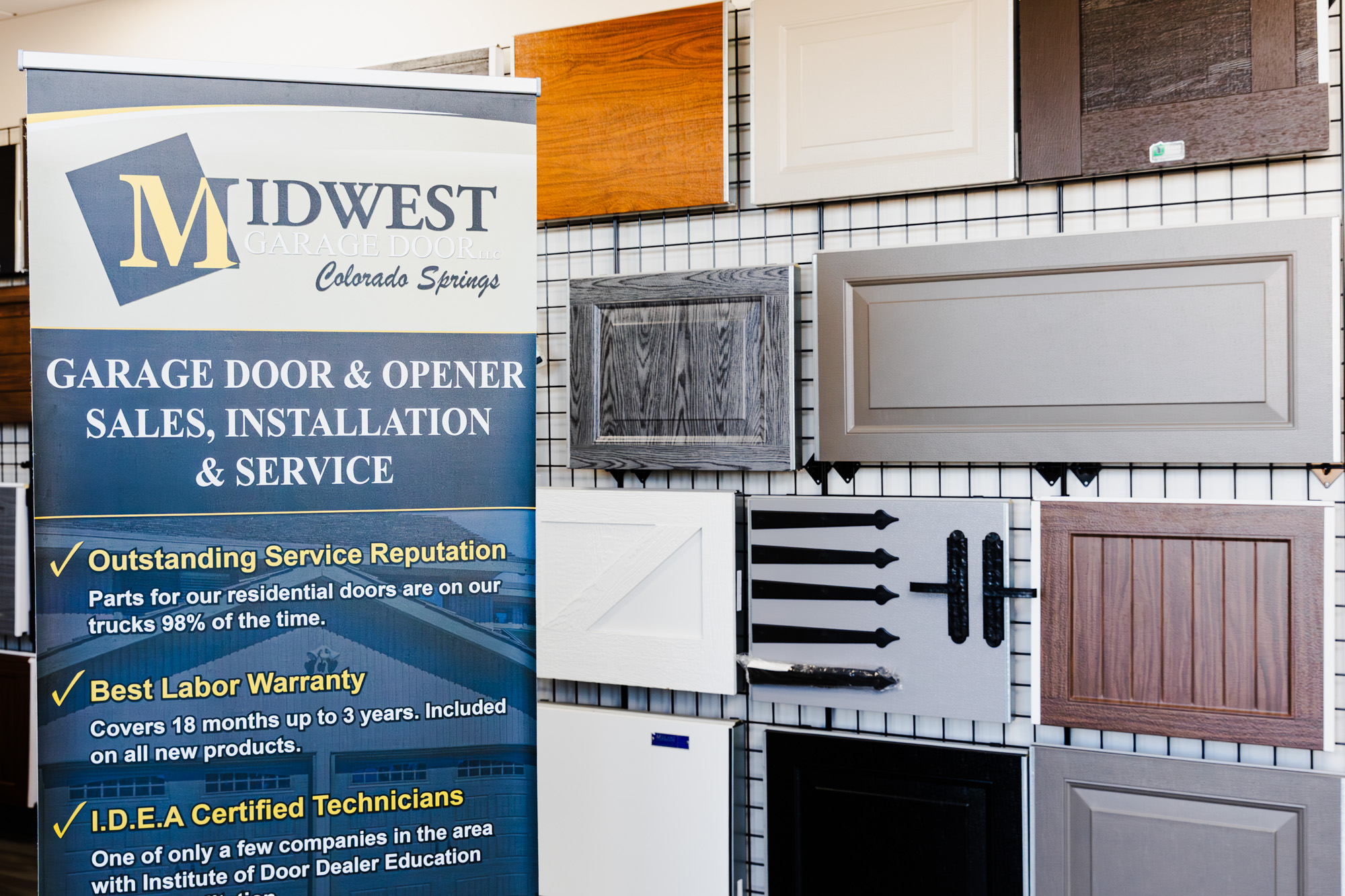 Garage door showroom display with product samples and informational signage.