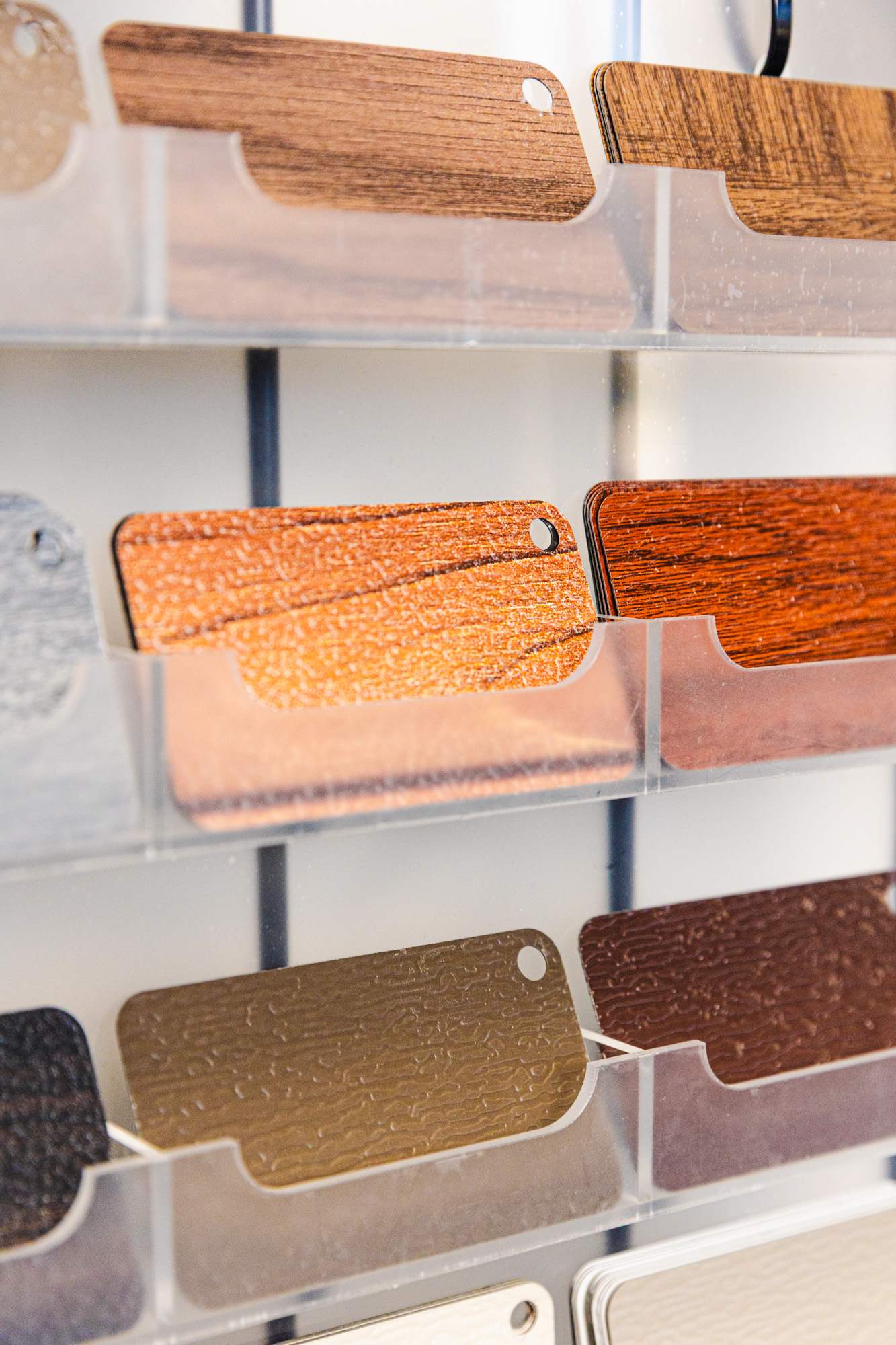 Display of garage door color and finish samples in orange, brown, gray, and neutral tones.